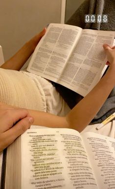 a person laying in bed with an open book