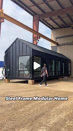 a man walking in front of a building with the words steel frame modular home on it