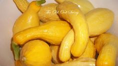 a pile of yellow cucumbers sitting on top of each other in a white bowl