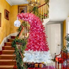 a red and white christmas tree sitting on top of a stair case