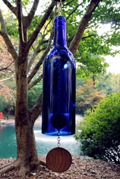 a blue glass bottle hanging from a tree