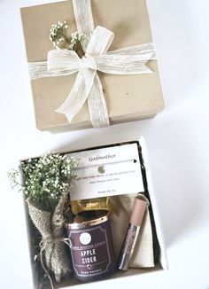 an open gift box with some flowers and other items in it on a white surface