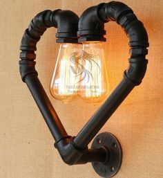 a light that is on the side of a wall with some pipes attached to it