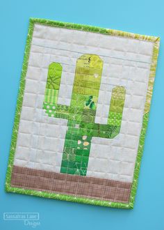 a green cactus quilted onto a blue background