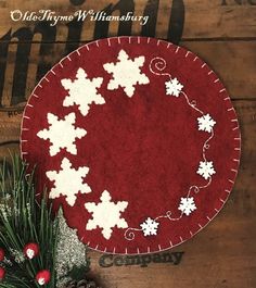 a red and white christmas ornament sitting on top of a wooden table next to pine cones