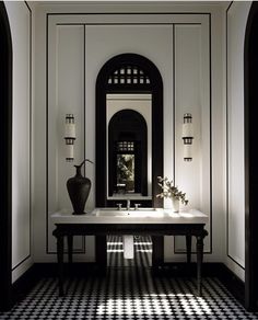 a black and white checkered floor in a bathroom with a large mirror on the wall