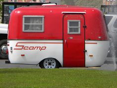 a red and white trailer parked in the grass