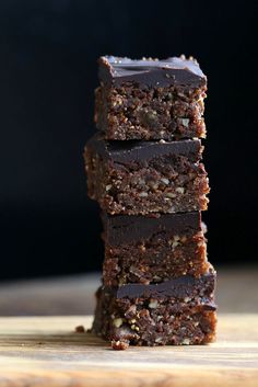 five pieces of chocolate brownie stacked on top of each other with nuts in the middle