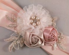 a pink sash with flowers and pearls on it