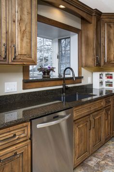 a kitchen with wooden cabinets and stainless steel dishwasher