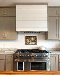 a stove top oven sitting inside of a kitchen next to wooden counter tops and cabinets