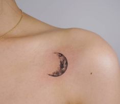 a woman's chest with a half moon tattoo on it