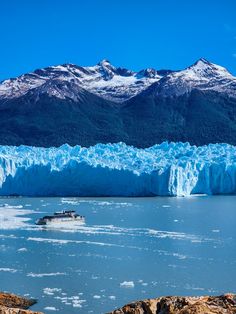 a boat is in the water near a large glacier