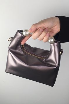 This petite yet striking purse offers a chic modern look with pearl details to elevate your outfit. Crafted from soft vegan leather, the purse features a top handle and a removable shoulder strap. The perfect companion for special occasions, this pearl handle purse will add a touch of refinement to any ensemble. Crossbody Evening Bag With Pearl Handle, Elegant Party Shoulder Bag With Zipper Closure, Elegant Party Bag With Zipper Closure, Evening Shoulder Bag With Pearl Top Handle, Evening Shoulder Bag With Pearl Handle, Elegant Evening Bag With Zipper Closure, Chic Bags With Pearl Top Handle, Evening Bags With Pearl Handle, Chic Bags With Pearl Handle