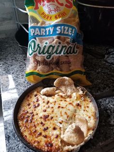 a bag of party size chips next to a pizza in a pan on the stove