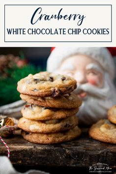 a stack of chocolate chip cookies with santa in the background and text overlay that reads cranberry white chocolate chip cookies