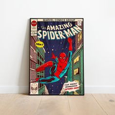 a spider - man comic book cover is displayed on a wooden floor in front of a white wall