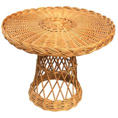 a wicker table with an oval top and circular base, on a white background