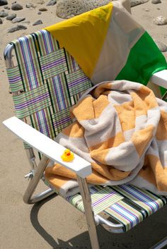 a beach chair with towels and a yellow rubber duck on it