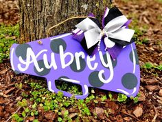 a purple sign with black and white polka dots on it that says auburn next to a tree