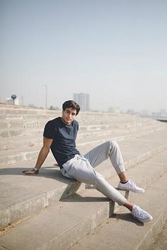 a young man sitting on some steps with his feet up