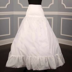 a white wedding dress on display in front of a wall