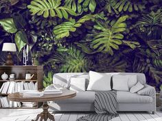 a living room filled with furniture and lots of green plants on the wall behind it