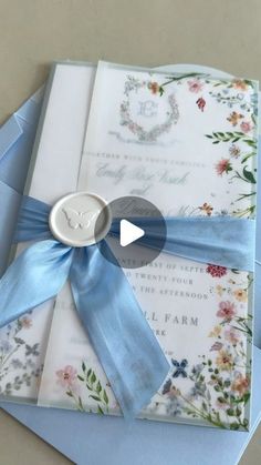 an open envelope with a blue ribbon and a button on it