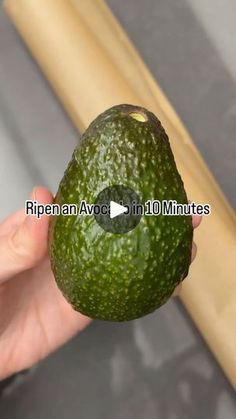 an avocado being held in front of a wooden stick with the words, ripen avocados in 10 minutes