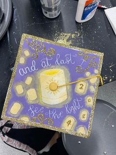 a purple and gold graduation cap that says and at last see the light on it