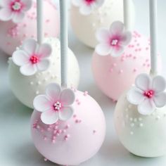 some pink and white cake pops with flowers on them