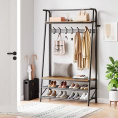 a coat rack with shoes and purses hanging on it in front of a door