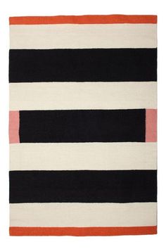 a black, white and orange rug with horizontal stripes on the bottom in different colors