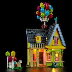 a toy house with balloons on top of it