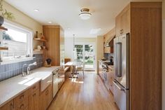 a kitchen with wooden cabinets and white counter tops next to a sliding glass door that leads to an outside patio