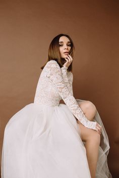 a woman in a white dress is sitting down