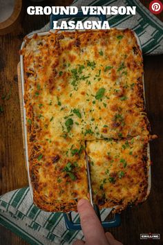 a person holding a piece of lasagna in front of a casserole dish