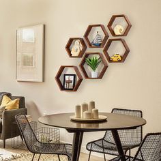 a dining room table with chairs and shelves on the wall above it that have floating hexagons