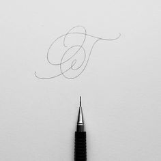 a pen is writing the letter e on a piece of paper