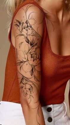 a woman's arm with flowers on it, and an orange shirt in the background