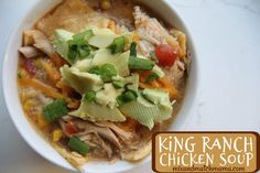 a bowl of chicken soup with avocado, tomatoes and other toppings on top