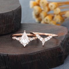 three different types of rings on top of a wooden table with flowers in the background