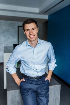 a man standing with his hands on his hips in front of the camera and smiling