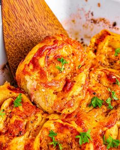 a close up of food in a pan on a wooden spatula with parsley