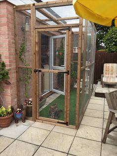 a small caged in area with plants and potted plants on the side of it