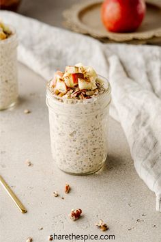 an oatmeal in a glass jar with apples and cinnamon on the side