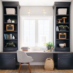 an office with black bookcases and white walls