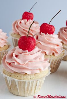 cupcakes with pink frosting and cherries on top are arranged in a row