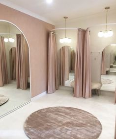 a large mirror sitting in the middle of a room next to a round rug on the floor