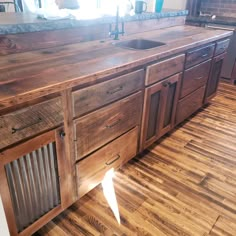 a kitchen with wooden cabinets and an island made out of pallet wood planks